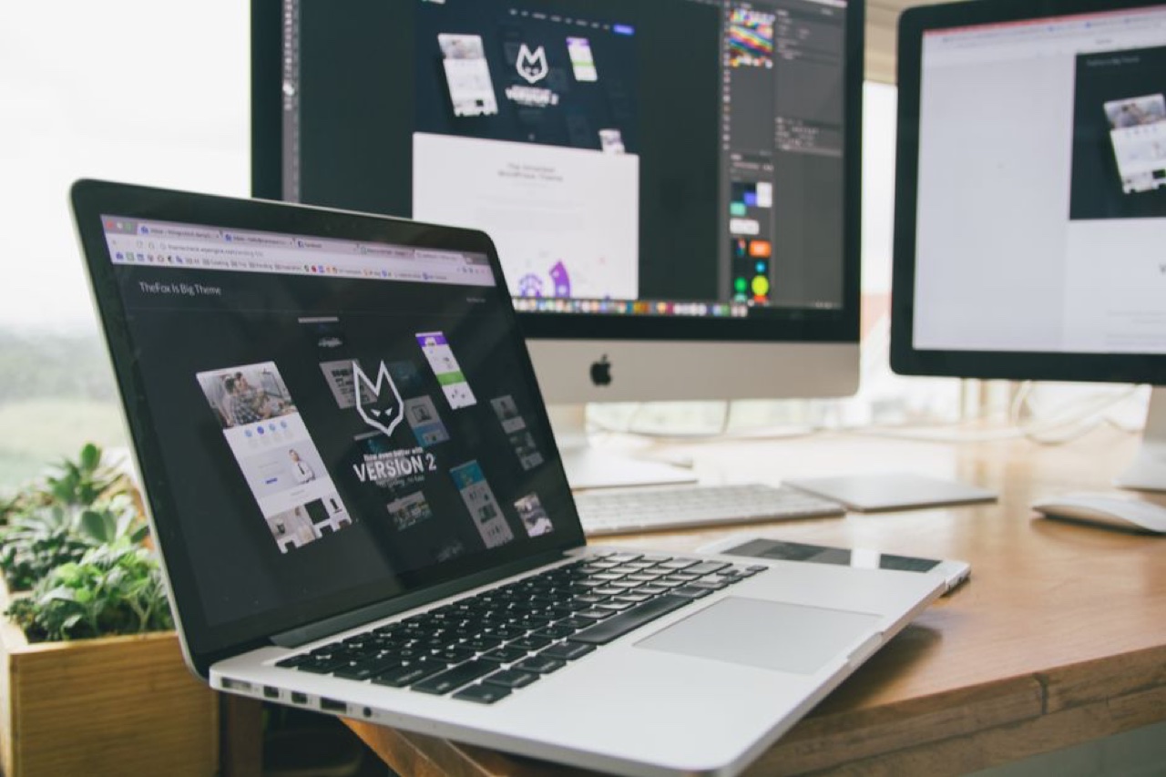 Poste de travail avec ordinateur portable et écrans affichant des sites web